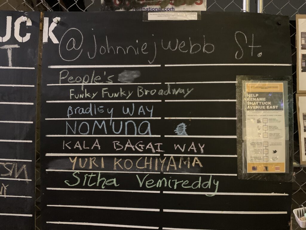 A picture of a blackboard with various street name ideas written in chalk. They include "Kala Bagai Way."